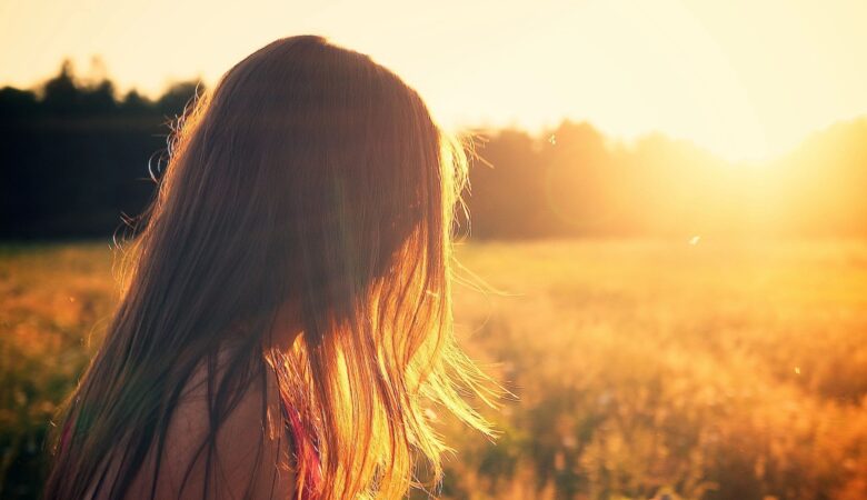 Downwards facing woman in field at dawn