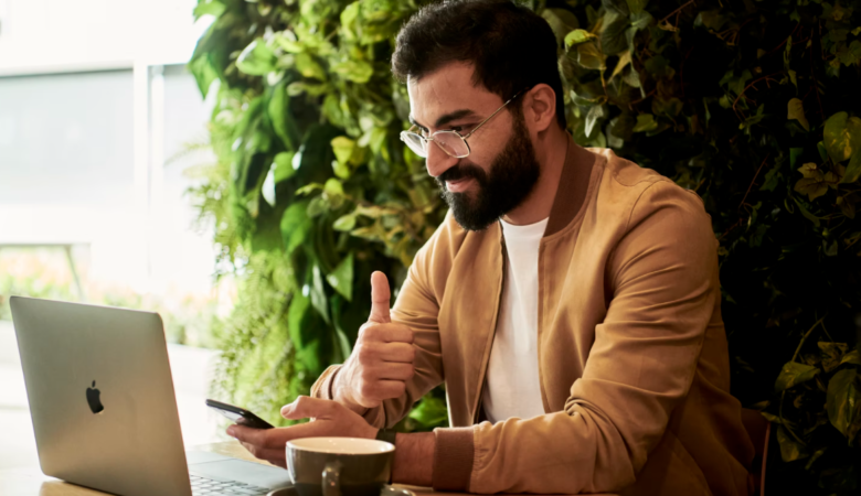 Businessman thumbs up working on laptop Creating A Work-Life Balance