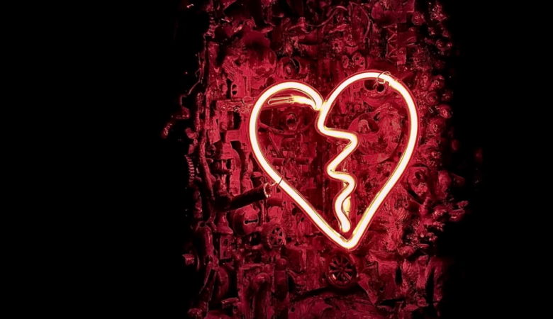 Broken neon heart on black background signifying signs of a toxic relationshipc