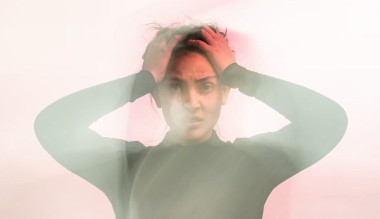 Blurry anxiety stricken woman holding head