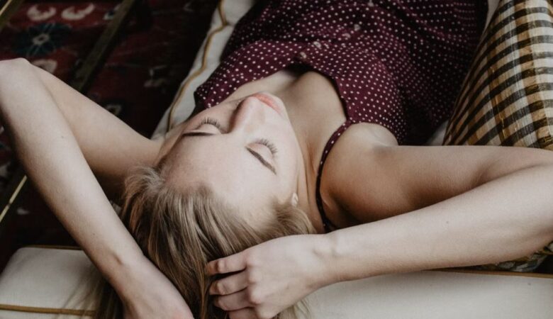 overwhelmed woman on bed holding head