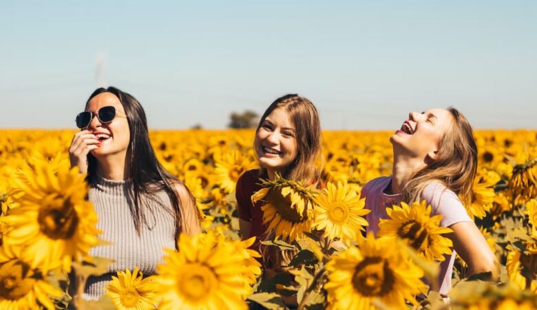 friends laughing in a sunflower field together