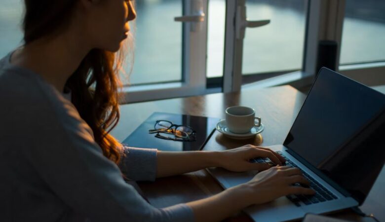 woman writing at desk in the dawn