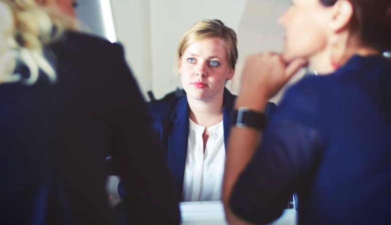 worried woman in job interview with two other women