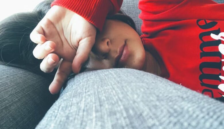 stressed out woman lying on sofa with arm across face