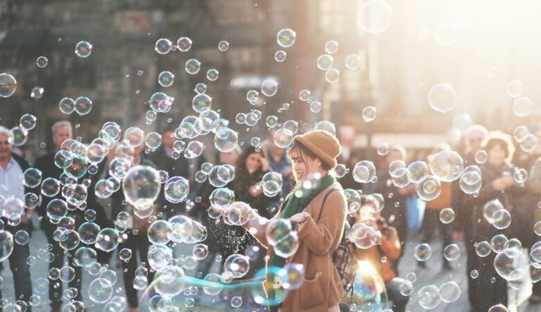 Happy woman enjoying being surrounded by bubbles whilst a crowd watches her