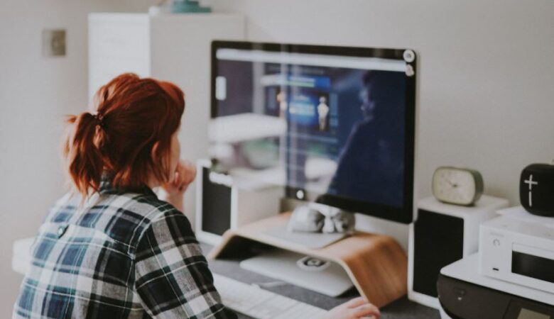 red haired women in chequered shirt working from home