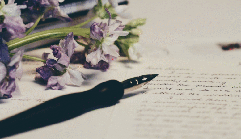 ink pen atop handwritten paper with purple flowers in background